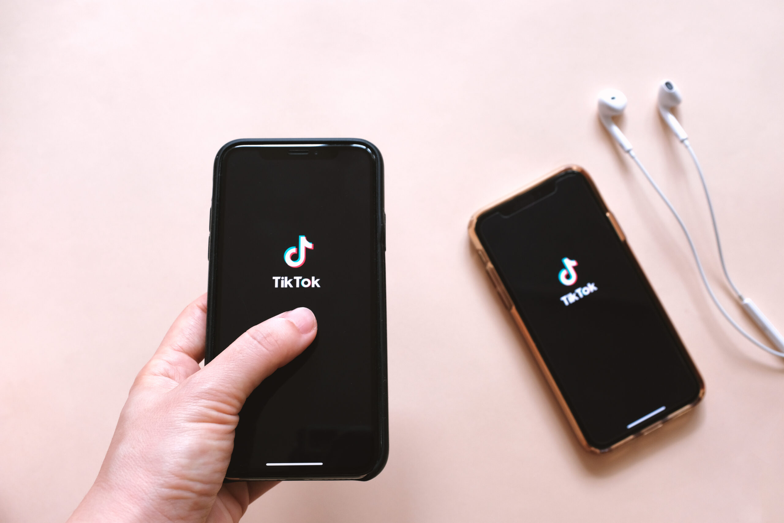 flat lay two smartphone hand holding mobile phone showing application screen with earphones scaled